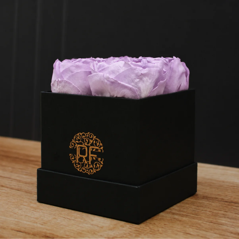 Caja cuadrada negra con 4 peonías preservadas color lavanda