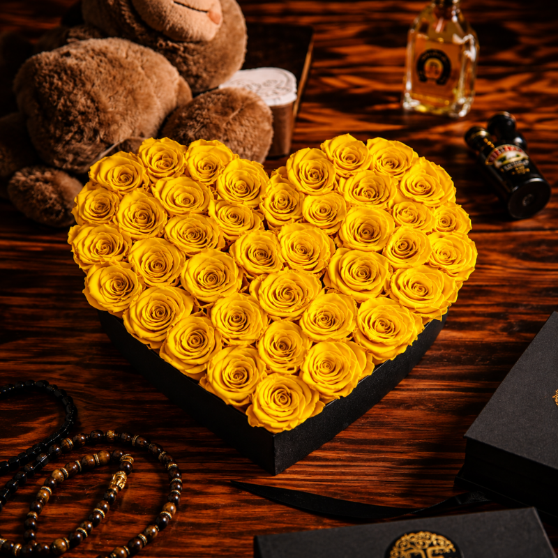 Caja de corazón negra con 55 rosas eternas amarillas preservadas acompañada de oso de peluche para regalo
